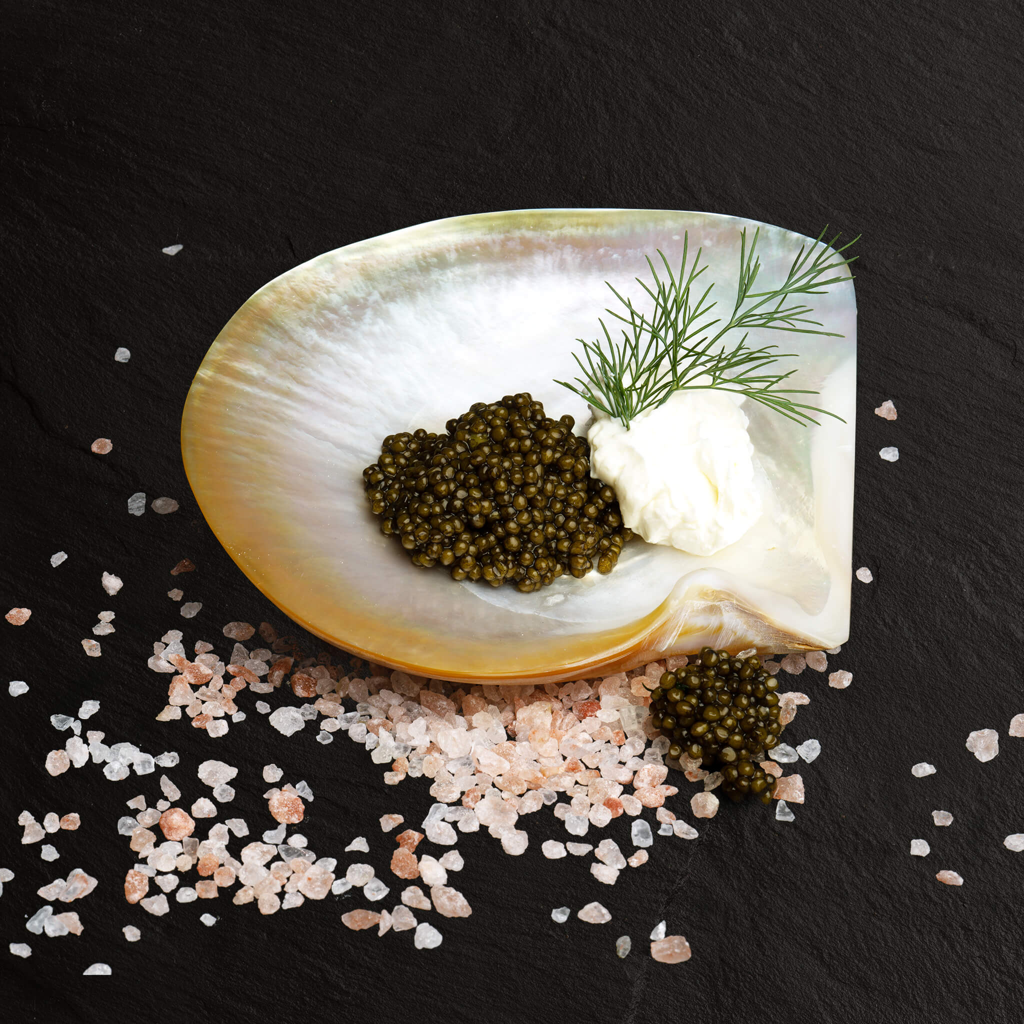 Mother-of-pearl serving bowl with Cavian caviar, cream and fresh dill