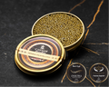Open Cavian Imperial Oscietra Gold caviar tin with lid placed in front and award badges on a dark marble background.